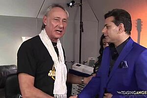 busty brunette milf bent over and drilled by two music producers on sofa