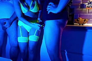 Wife eagerly sucks two cocks in neon threesome. She swallows cum and gets facial.