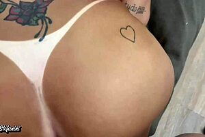 blonde woman catches husband's attention while he watches tv