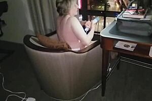 Naked granny masturbates in hotel, flashing city at night.