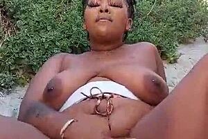 Watch me squirt outdoors, the ebony milf says while fingering her big natural tits and pussy