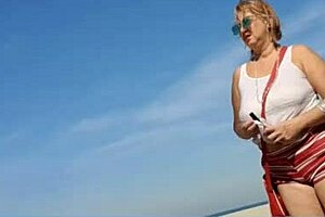 Far out! This sexy African milf flashes big natural tits and pussy lips on the beach.