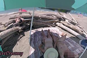 Exhibitionist wife gives outdoor amateur milf handjob to big cock on nudity beach in front of voyeur with cumshot